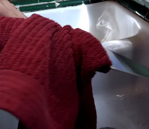 knife being dried with a red towel